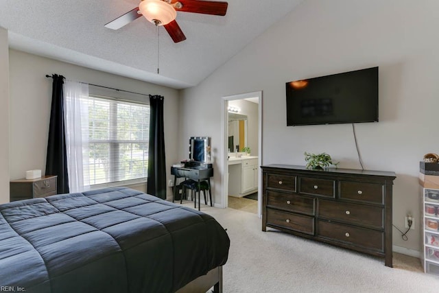 bedroom with light colored carpet, a ceiling fan, ensuite bathroom, and lofted ceiling