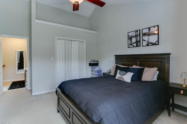 bedroom featuring carpet floors, high vaulted ceiling, a ceiling fan, baseboards, and a closet