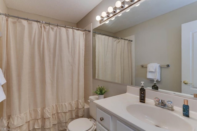 bathroom featuring vanity, a textured ceiling, and toilet