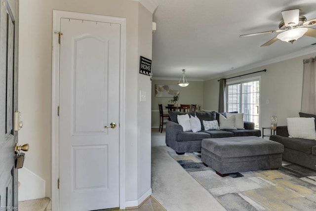 living room featuring crown molding and a ceiling fan