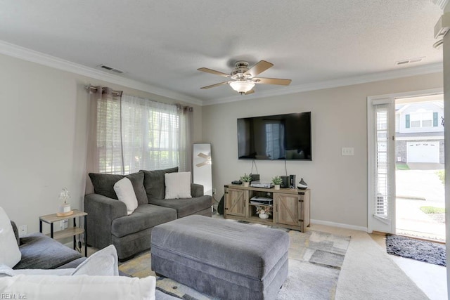living room with a ceiling fan, light colored carpet, visible vents, and ornamental molding