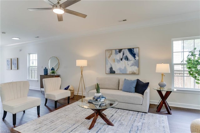 living area featuring crown molding, visible vents, dark wood-style floors, and a wealth of natural light
