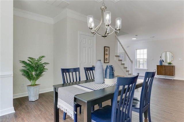 dining area with an inviting chandelier, baseboards, crown molding, and wood finished floors