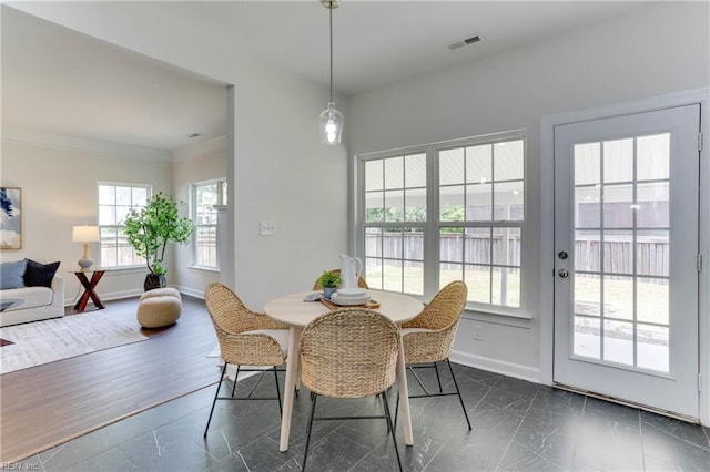 dining room with crown molding, baseboards, and visible vents