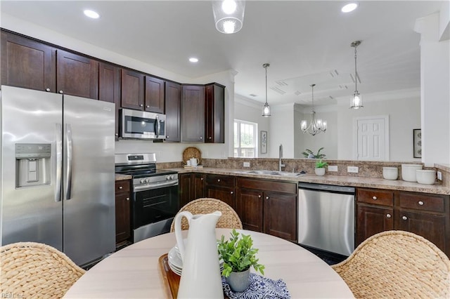 kitchen with crown molding, pendant lighting, dark brown cabinets, a sink, and stainless steel appliances