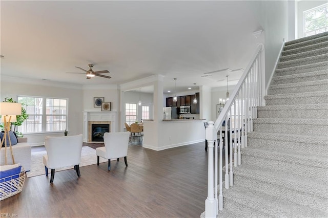 living room with plenty of natural light, stairs, and dark wood-style floors