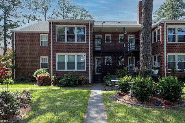 8562 Executive Dr Unit B2, Norfolk, VA 23503 - view of front of house featuring stairway, brick siding, a chimney, and a front yard