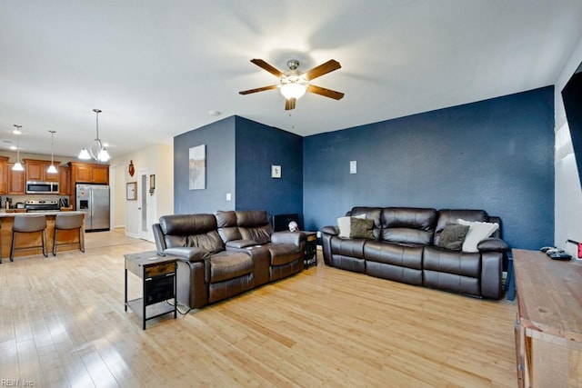 living area with a ceiling fan and light wood finished floors