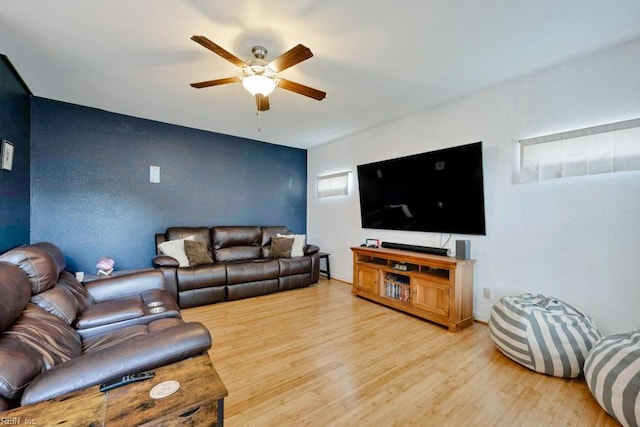 living area with a ceiling fan and wood finished floors