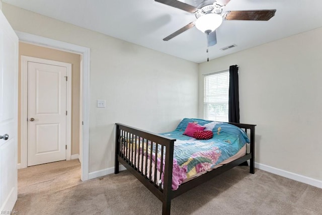 bedroom with baseboards, light colored carpet, ceiling fan, and visible vents