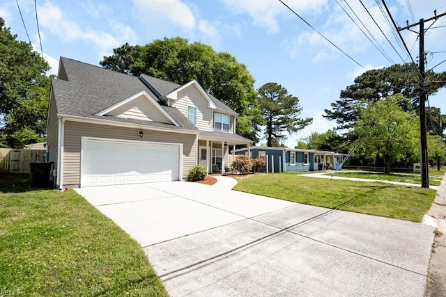 view of front facade with a front lawn, fence, roof with shingles, an attached garage, and driveway
