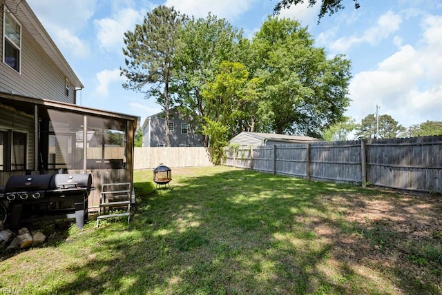 view of yard with a sunroom and a fenced backyard