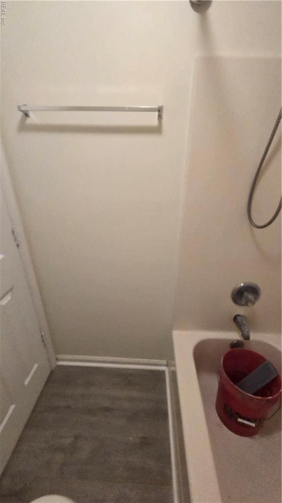 full bath with baseboards and shower / washtub combination