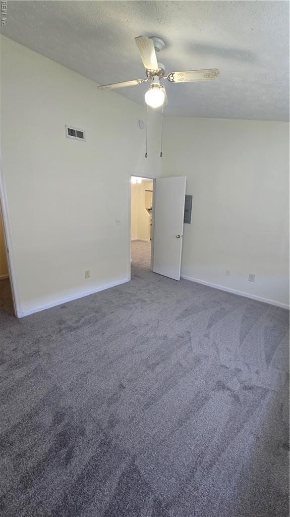 carpeted spare room featuring a textured ceiling, ceiling fan, visible vents, and baseboards