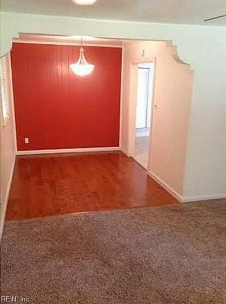 carpeted empty room featuring baseboards