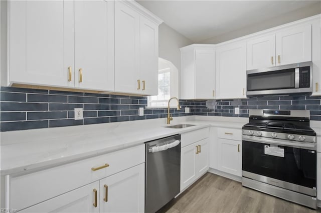 3612 Purebred Dr, Virginia Beach, VA 23453 - kitchen featuring white cabinets, light stone countertops, a sink, light wood finished floors, and stainless steel appliances