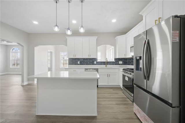 3612 Purebred Dr, Virginia Beach, VA 23453 - kitchen featuring appliances with stainless steel finishes, light countertops, a center island, white cabinetry, and backsplash