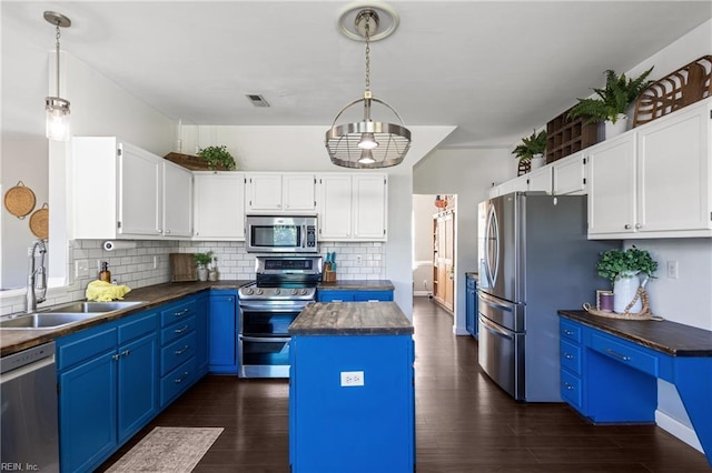 kitchen featuring decorative backsplash, dark wood-type flooring, blue cabinets, a sink, and appliances with stainless steel finishes