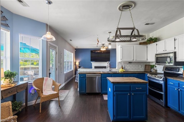 kitchen featuring appliances with stainless steel finishes, a sink, visible vents, and blue cabinets