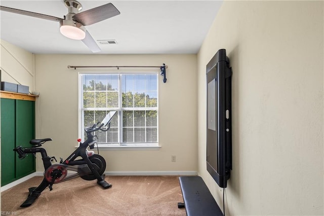 workout area featuring baseboards, visible vents, ceiling fan, and carpet