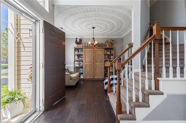 foyer featuring an inviting chandelier, dark wood finished floors, stairs, and a wealth of natural light