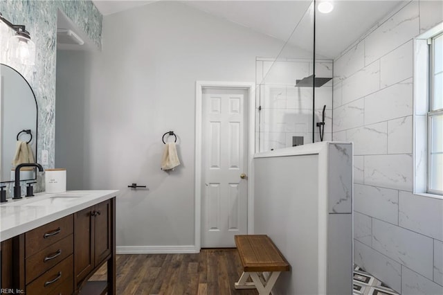 bathroom with a healthy amount of sunlight, a walk in shower, wood finished floors, and lofted ceiling