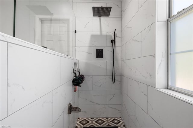 bathroom featuring a tile shower and a wealth of natural light