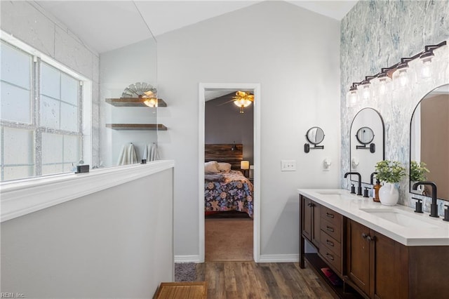 bathroom with a sink, lofted ceiling, and wood finished floors