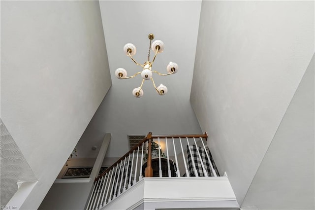 staircase with a chandelier and a towering ceiling