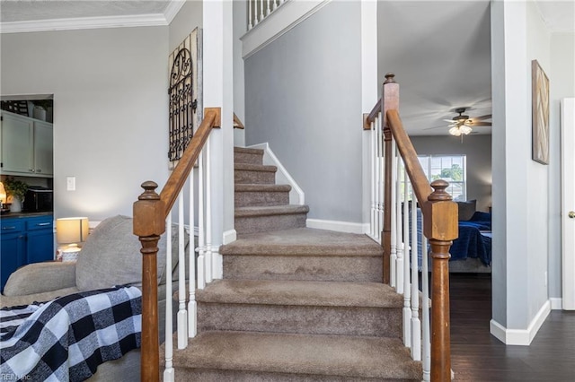 stairs featuring baseboards, a ceiling fan, crown molding, and wood finished floors