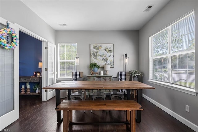 dining area with baseboards, wood finished floors, and visible vents