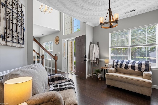 living room with visible vents, stairs, wood finished floors, and a notable chandelier