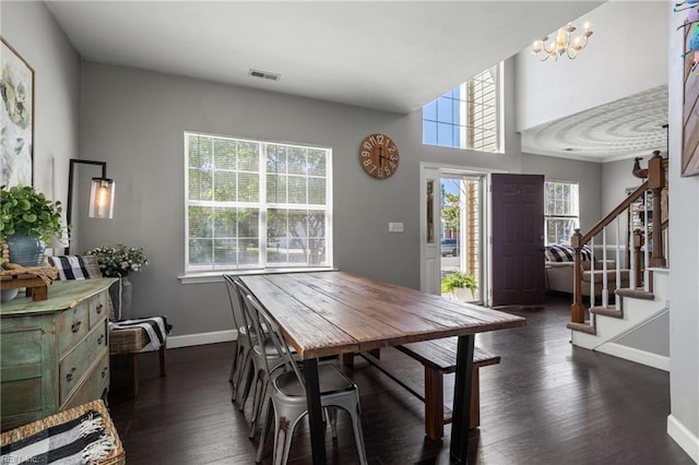 dining space with visible vents, baseboards, stairway, a chandelier, and dark wood finished floors
