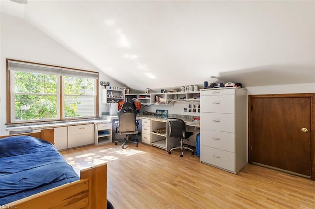 home office featuring light wood-type flooring, built in study area, and vaulted ceiling