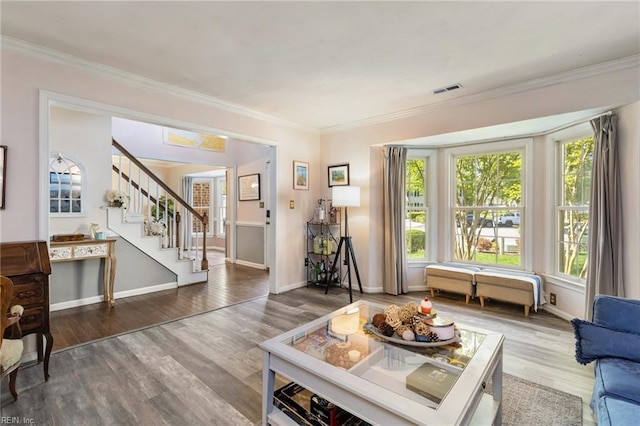 living room featuring crown molding, wood finished floors, and visible vents