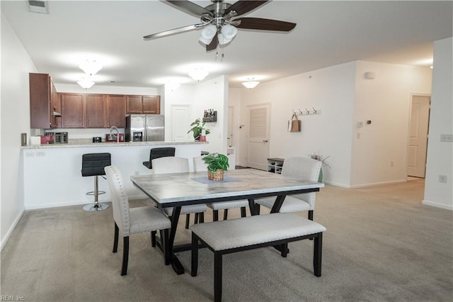 dining area with visible vents, a ceiling fan, baseboards, and light colored carpet