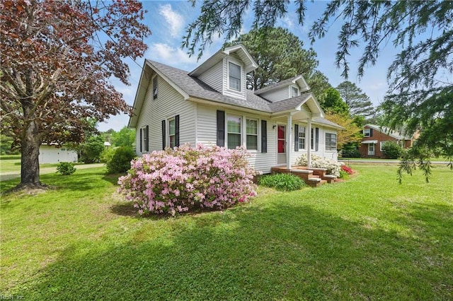 view of side of home featuring roof with shingles and a yard