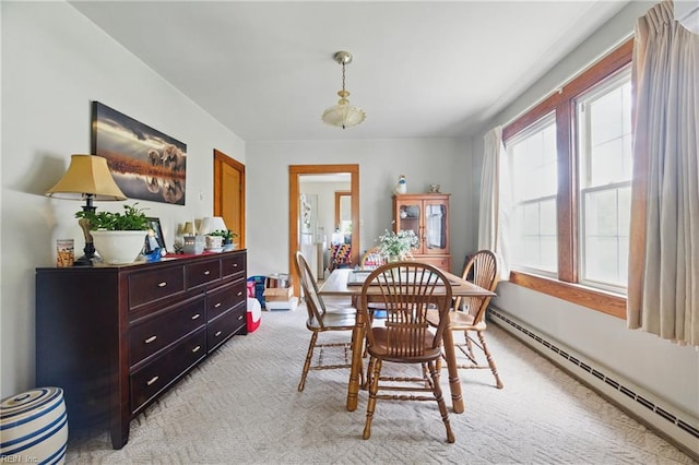 dining space with light colored carpet and a baseboard heating unit