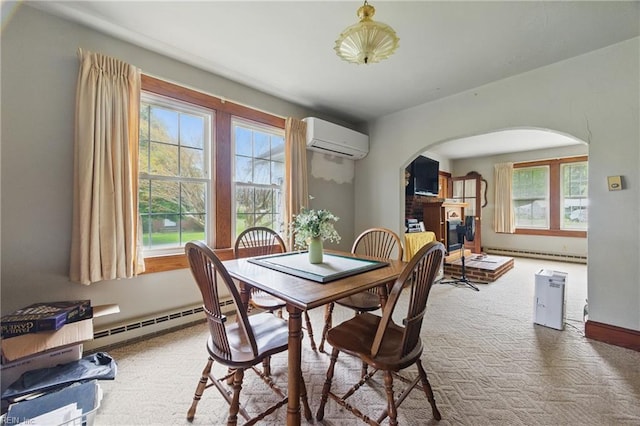 dining area with an AC wall unit, arched walkways, a baseboard heating unit, and carpet
