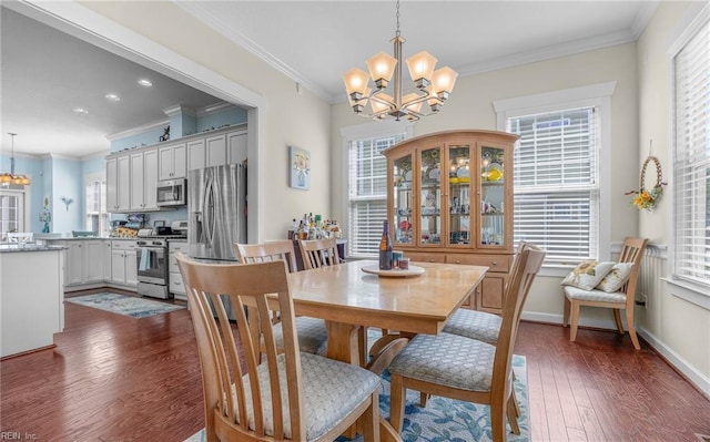 dining area with crown molding, recessed lighting, dark wood-style flooring, and a notable chandelier
