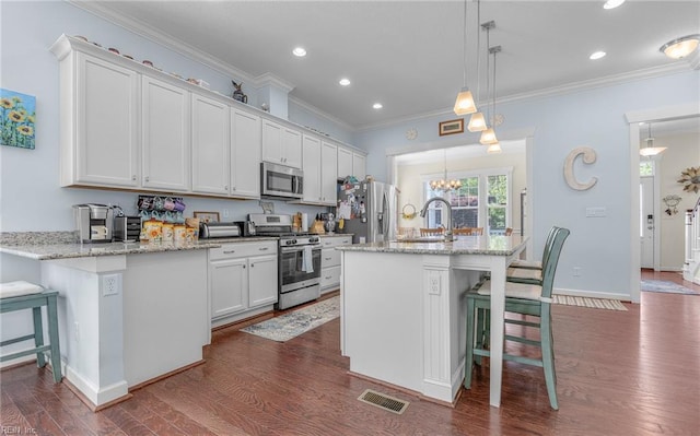 kitchen with stainless steel appliances, a breakfast bar, a sink, and dark wood-type flooring