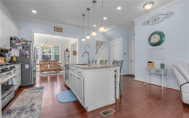 kitchen with visible vents, a sink, a notable chandelier, ornamental molding, and stainless steel appliances
