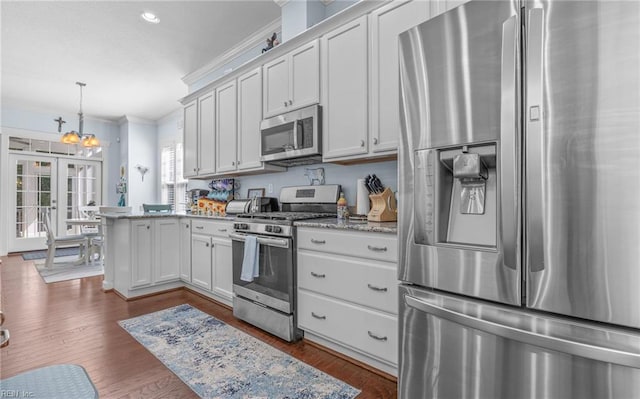 kitchen featuring crown molding, dark wood-style flooring, a peninsula, and stainless steel appliances