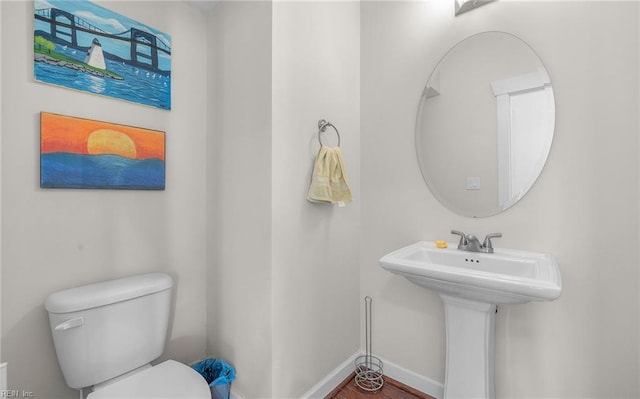 bathroom with baseboards and toilet