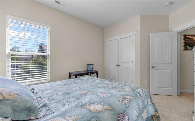 carpeted bedroom featuring visible vents, baseboards, and a closet