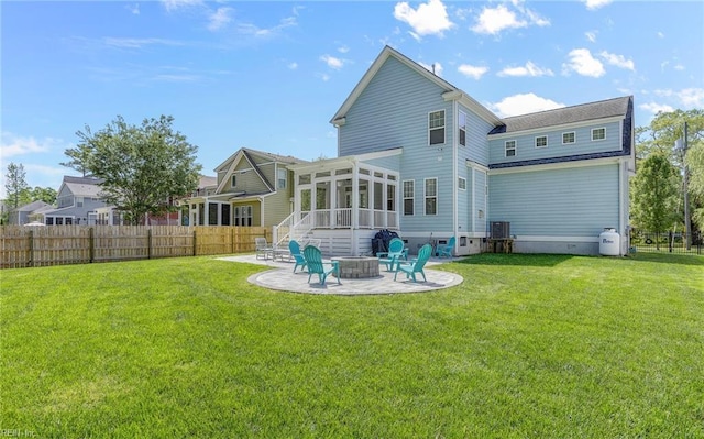 rear view of house with a sunroom, a patio area, fence, and an outdoor fire pit