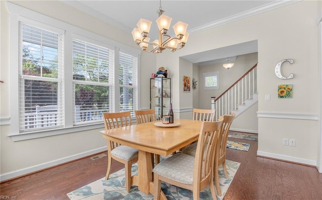 dining room featuring plenty of natural light, a chandelier, visible vents, and wood finished floors