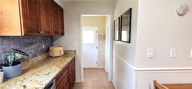 kitchen featuring light stone counters, decorative backsplash, and light tile patterned flooring