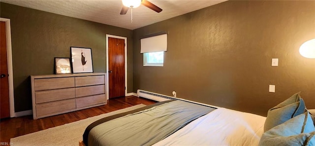 bedroom with baseboards, a textured wall, a ceiling fan, and dark wood finished floors