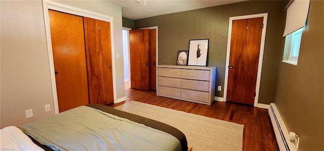 bedroom with dark wood-style flooring, baseboards, a closet, and a baseboard radiator